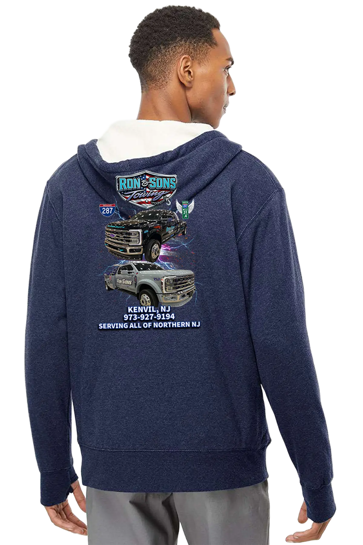Person wearing a navy blue hoodie with graphics and text on the back, standing against a white background. Ron and Sons Towing, Paper Street Print Co, Blairstown, NJ.