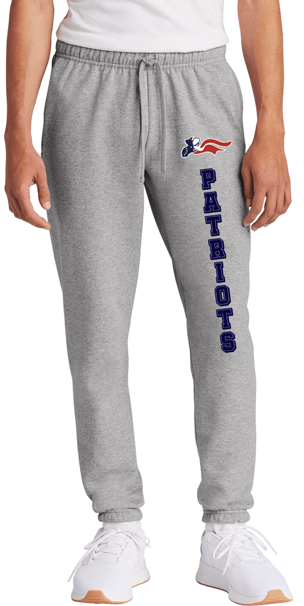 A pair of gray fleece sweatpants with 'Patriots' written on the side in a blue and red color scheme, consistent with a sports team branding.