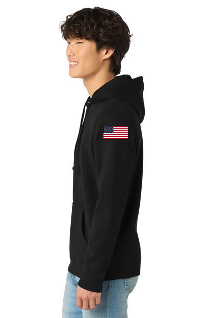 Person wearing a black hoodie with an American flag patch on the sleeve against a white background. BRT Towing & Recovery, Paper Street Print Co, Blairstown, NJ.