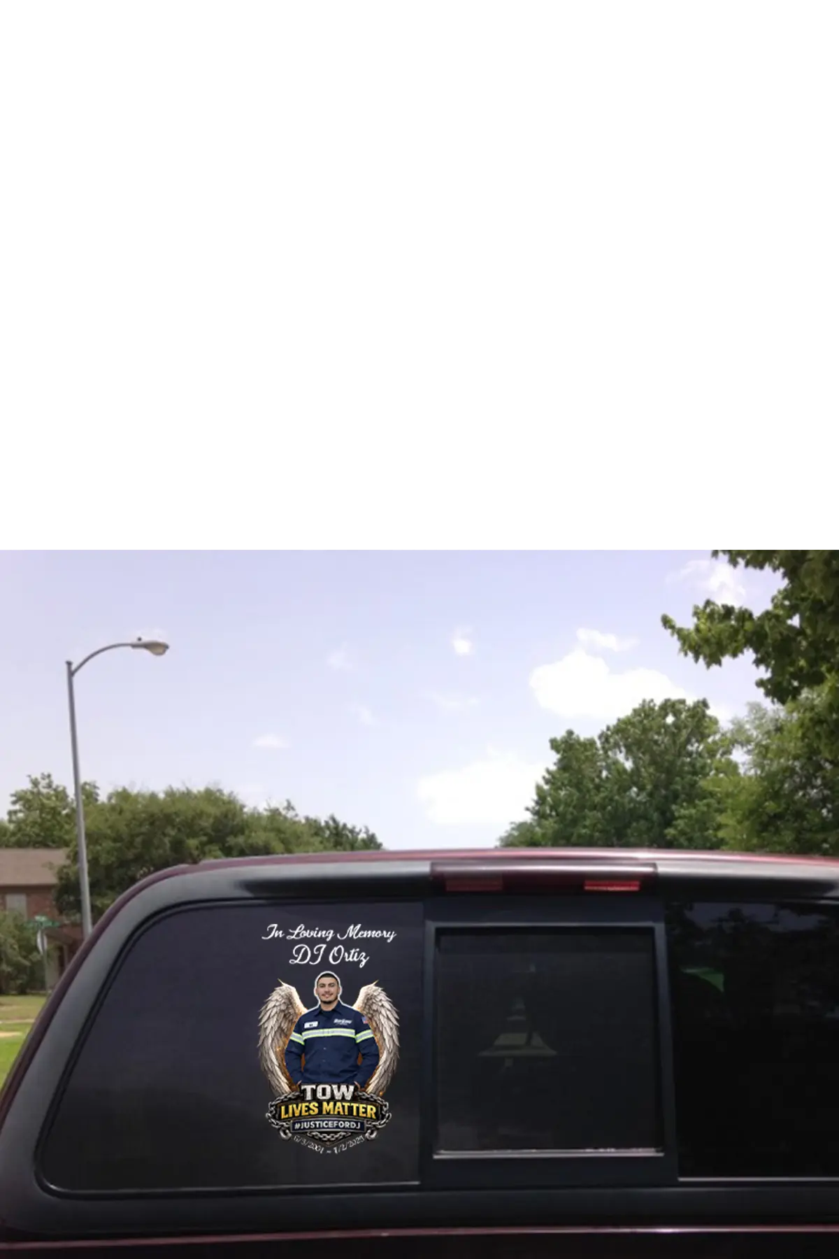 Car window with a memorial decal for DJ Otis, featuring an angelic figure and text. "In Loving Memory of DJ Ortiz" TOW Lives Matter, #JusticeforDJ - Paper Street Print Co, Blairstown, NJ.