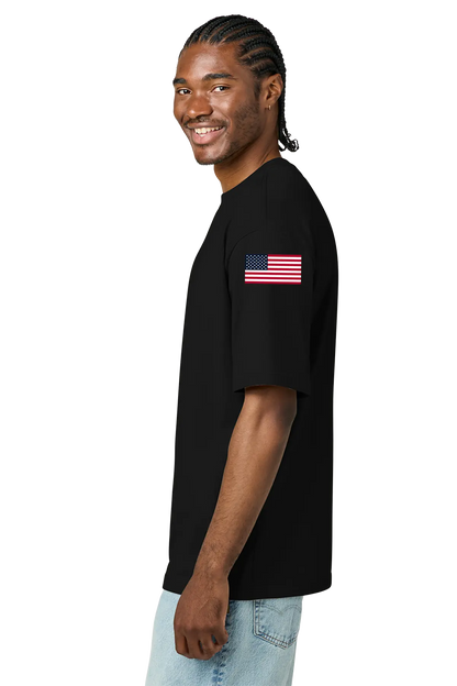 Man wearing a black t-shirt with an American flag on the sleeve against a white background. BRT Towing and Recovery, Paper Street Print Co, Blairstown, NJ.