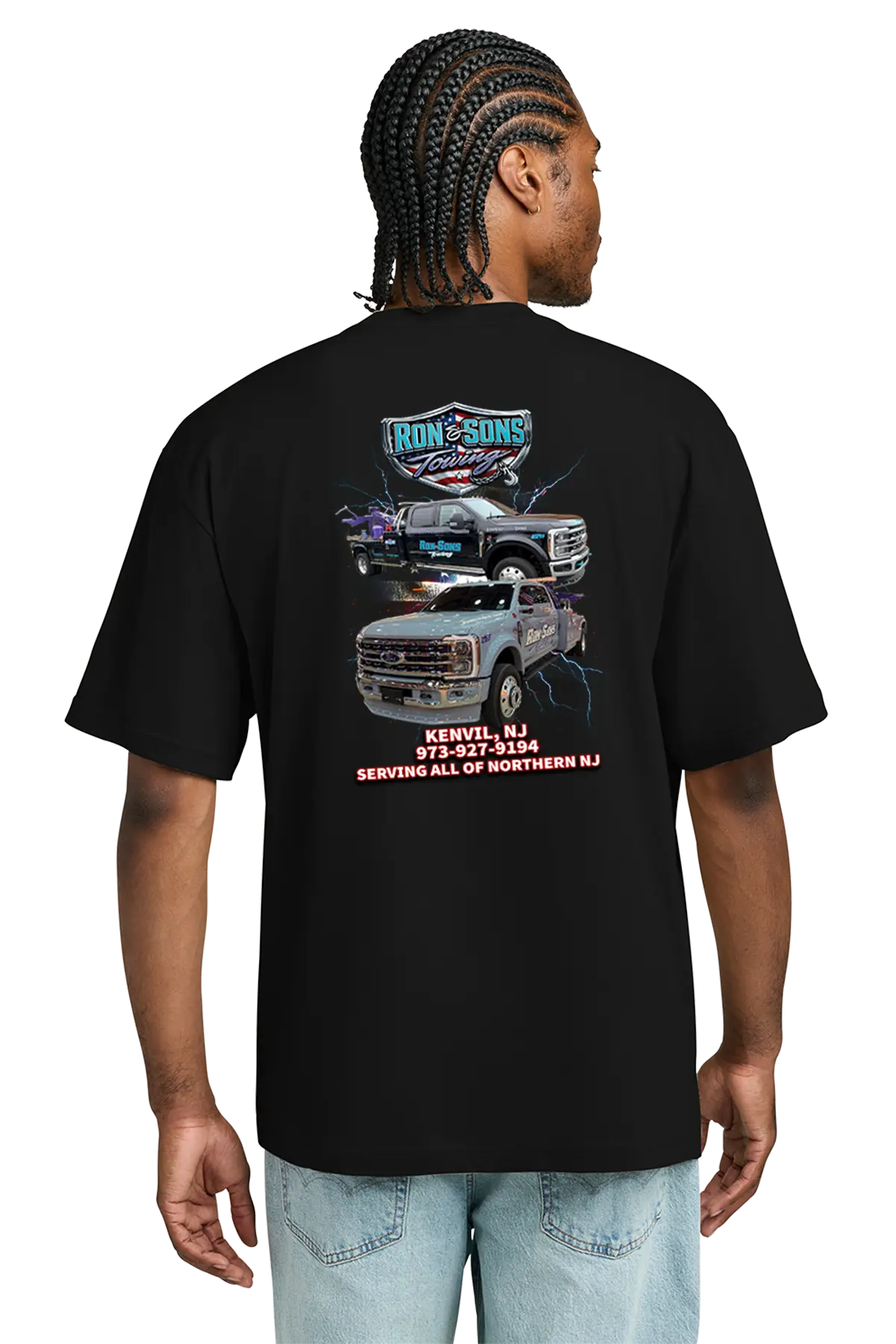 Person wearing a black t-shirt with graphics and text on the back, standing against a white background. Ron and Sons Towing, Paper Street Print Co, Blairstown, NJ.