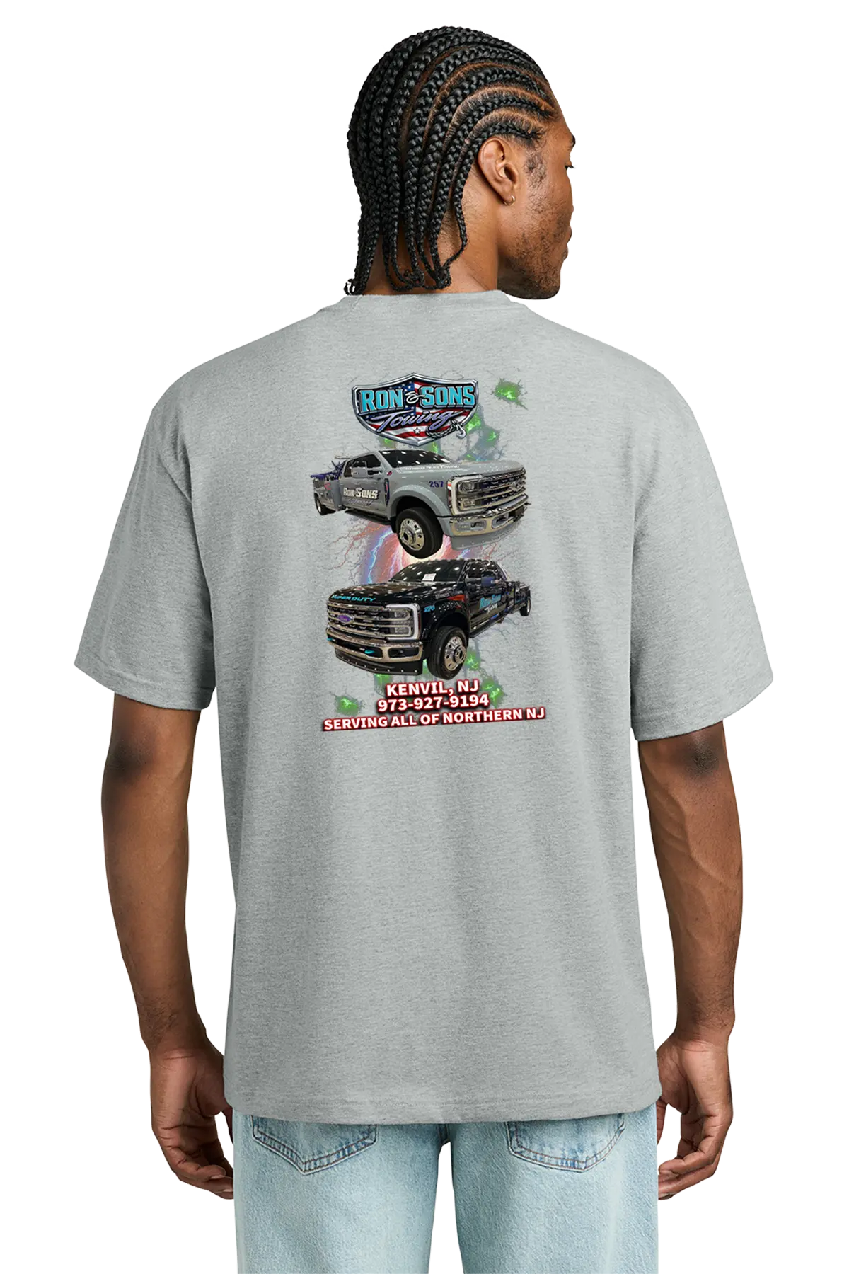 Person wearing a gray t-shirt with a graphic design on the back, featuring trucks and text. Ron and Sons Towing, Paper Street Print Co, Blairstown, NJ.