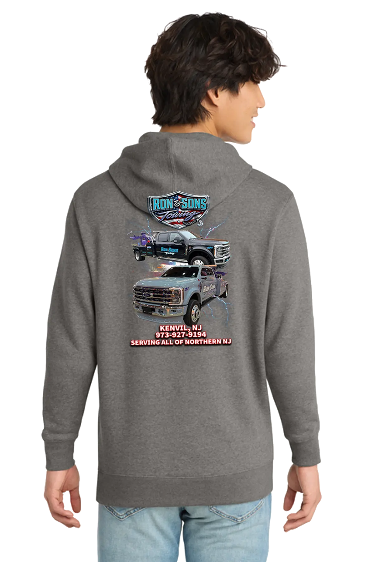 Person wearing a gray hoodie with a truck graphic and text on the back, standing against a white background. Ron and Sons Towing, Paper Street Print Co, Blairstown, NJ.