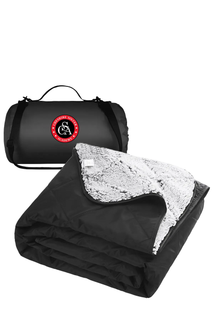 Black and white blanket with a carrying bag featuring a logo on a white background. CSA Cheshire Soccer Academy, Paper Street Print Co, Blairstown, NJ.