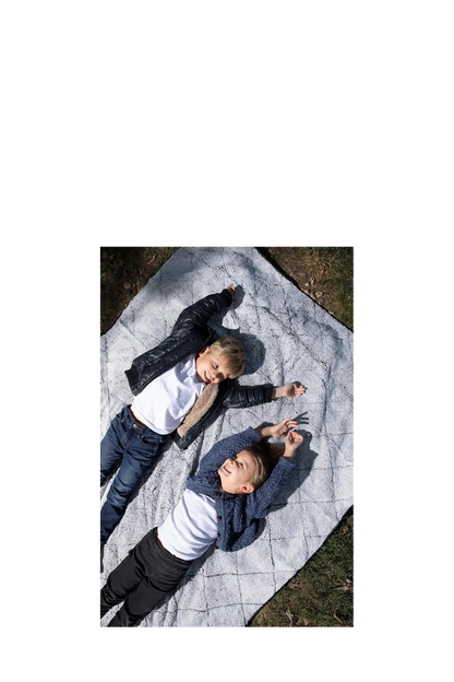 Two children lying on a very comfortable waterproof blanket outdoors. CSA Cheshire Soccer Academy, Paper Street Print Co, Blairstown, NJ.