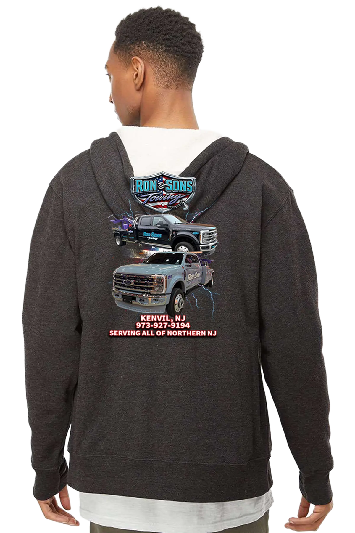 Person wearing a dark hoodie with truck graphics and text on the back, on a white background. Ron and Sons Towing, Paper Street Print Co, Blairstown, NJ.