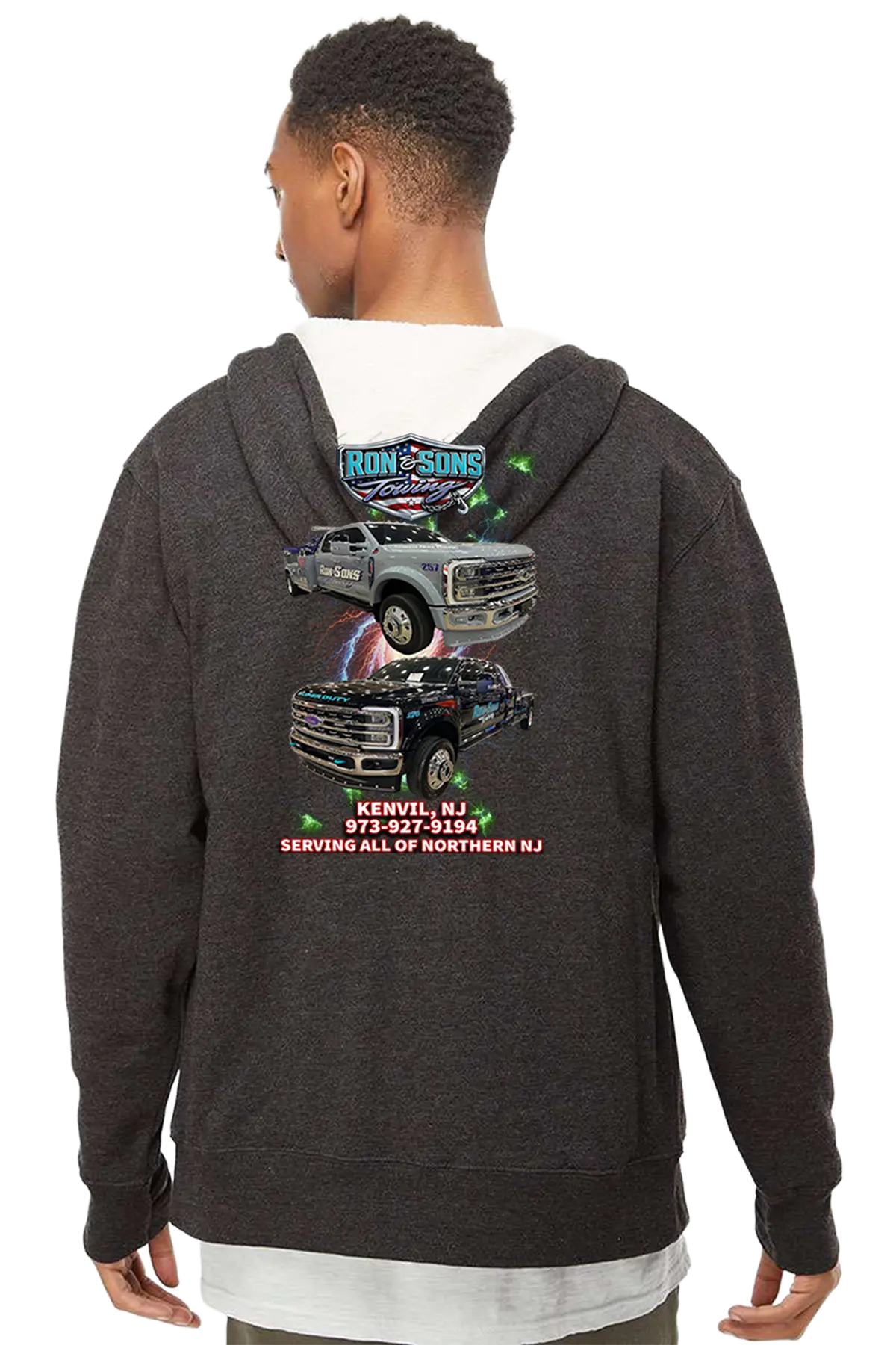 Person wearing a dark gray hoodie with truck graphics and text on the back, on a white background. Ron and Sons Towing, Paper Street Print Co, Blairstown, NJ.