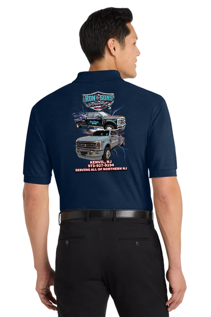 Man wearing a navy blue shirt with a graphic of trucks on the back, standing against a white background. Ron and Sons Towing, Paper Street Print Co, Blairstown, NJ.