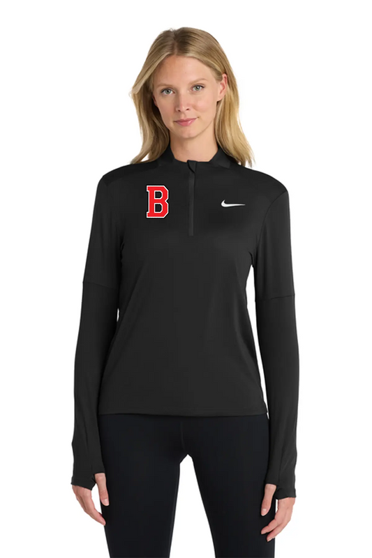 A woman modeling a black long-sleeve half-zip athletic pullover with a red Boston 'B' logo on the left chest and a white Nike swoosh on the right chest, paired with black leggings against a plain white background. Belvidere Lady Seaters Basketball, Paper Street Print Co, Blairstown, NJ.
