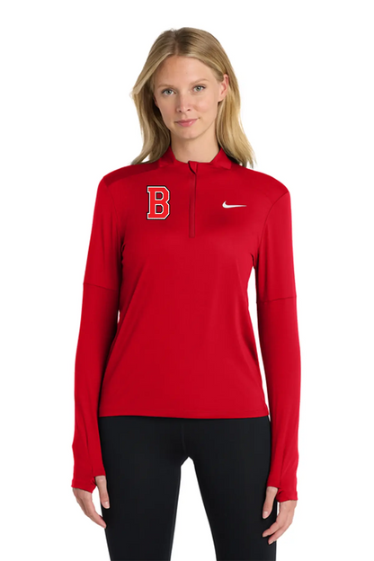 A woman modeling a red long-sleeve half-zip athletic pullover with a red 'B' logo on the left chest and a white Nike swoosh on the right chest, paired with black leggings against a plain white background. Belvidere Lady Seaters Basketball, Paper Street Print Co, Blairstown, NJ.