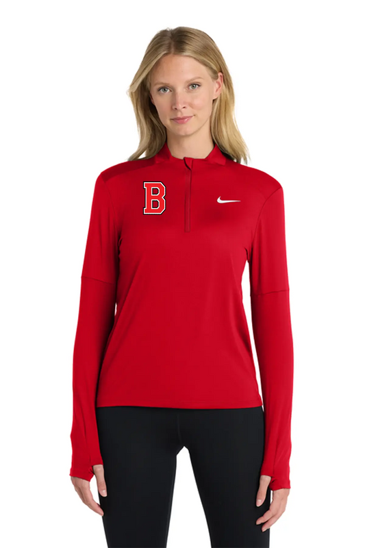 A woman modeling a red long-sleeve half-zip athletic pullover with a red 'B' logo on the left chest and a white Nike swoosh on the right chest, paired with black leggings against a plain white background. Belvidere Lady Seaters Basketball, Paper Street Print Co, Blairstown, NJ.