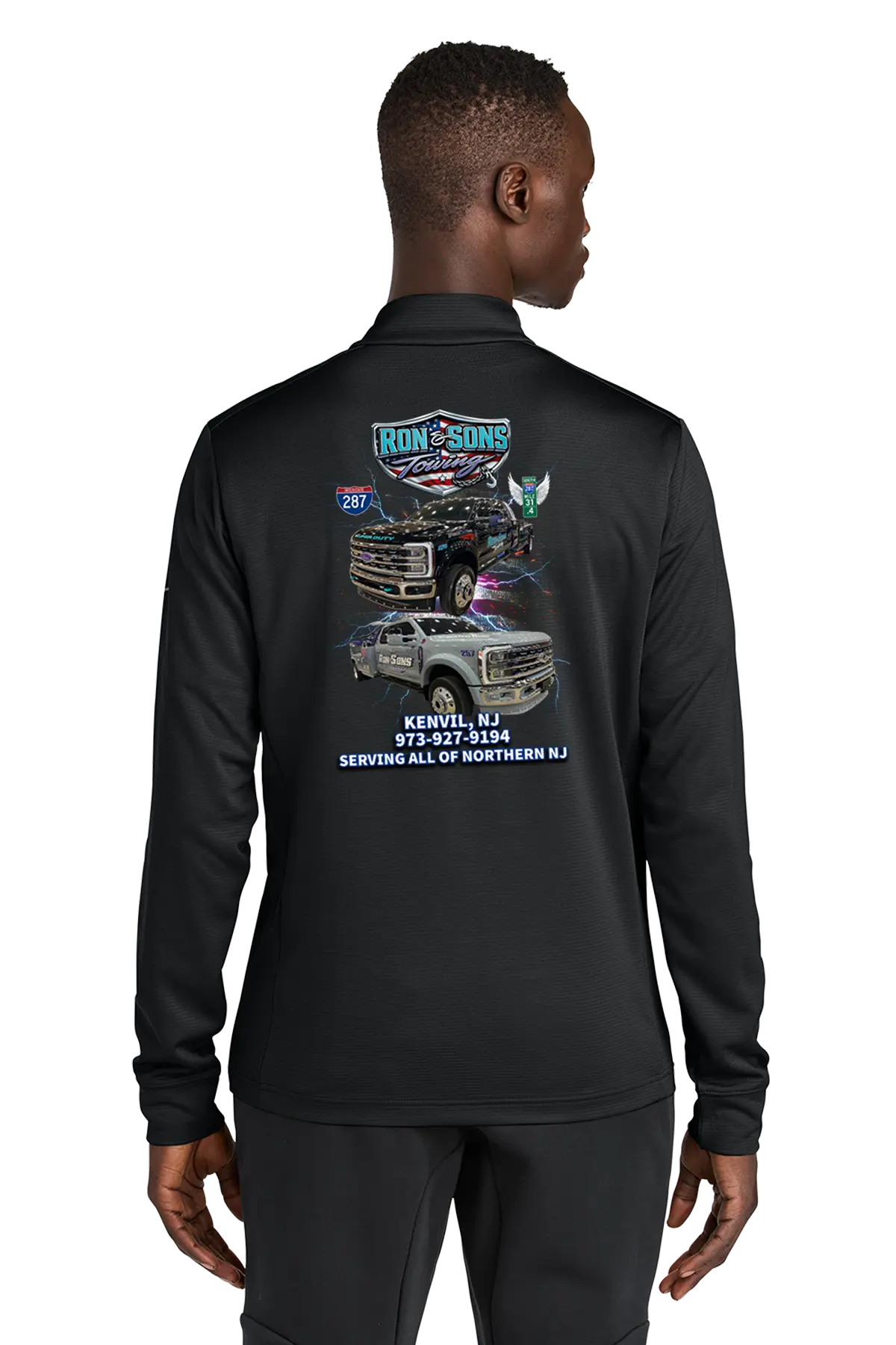 Person wearing a black long-sleeve shirt with graphics and text on the back, on a white background. Ron and Sons Towing, Paper Street Print Co, Blairstown, NJ.