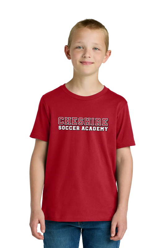 Child wearing a red 'Cheshire Soccer Academy' t-shirt on a white background. Paper Street Print Co, Blairstown, NJ.
