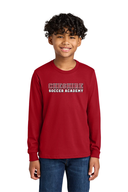 Child wearing a red 'Cheshire Soccer Academy' long-sleeve shirt on a white background. Paper Street Print Co, Blairstown, NJ.