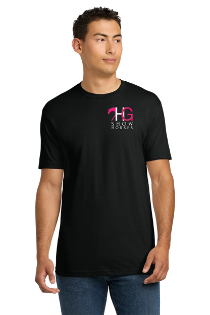 A man wearing a black short-sleeve crewneck t-shirt with a pink and white 'HG SHOW HORSES' logo on the left chest, paired with blue jeans, set against a plain white background. HG Show Horses, Paper Street Print Co, Blairstown, NJ.