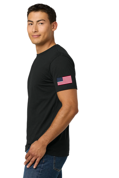 Man wearing a black t-shirt with an American flag on the sleeve against a white background. #JusticeforDJ - Paper Street Print Co, Blairstown, NJ.