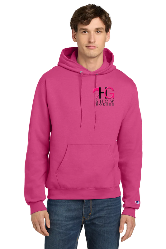 A man wearing a bright pink pullover hoodie with a 'HG SHOW HORSES' logo on the left chest and a small Champion logo on the right sleeve cuff, paired with blue jeans, against a plain white background. HG Show Horses, Paper Street Print Co, Blairstown, NJ.